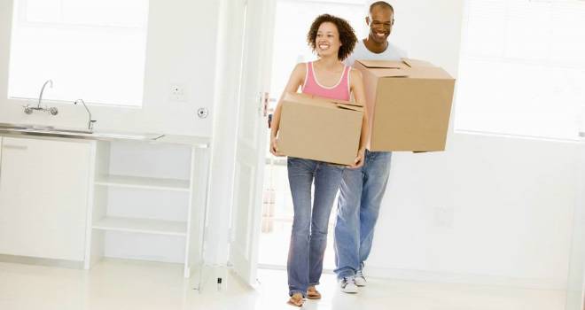FTB mortgages down in March - but remortgage goes from strength to strength young ftb couple with boxes