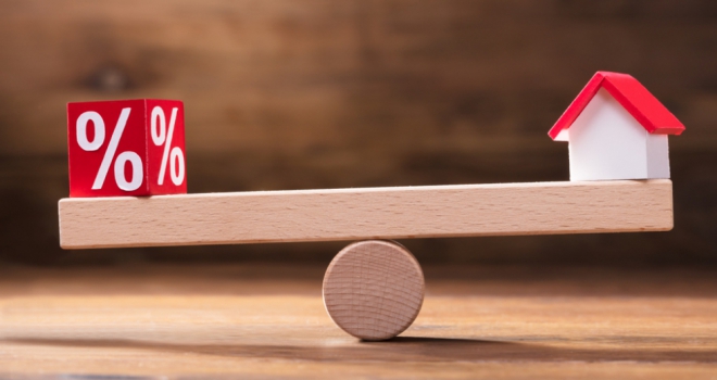 Housing market remains subdued amidst Autumn Budget uncertainty: RICS balancing scales with a house and a percentage sign