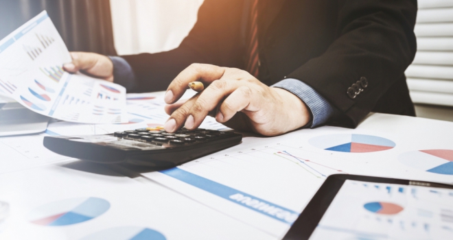 Catalyst launches new specialist buy-to-let product man in business suit with calculator surrounded by graphs and paperwork