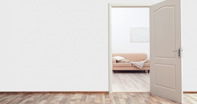 The new normal for conveyancing a wooden door in a white wall showing a living room through the gap