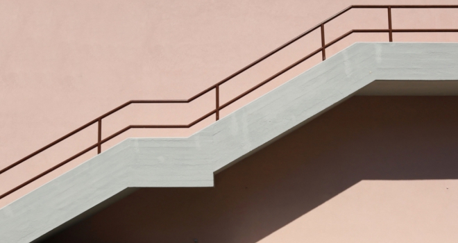 London Credit increases maximum LTV Concrete staircase with brown metallic railing on pink painted facade