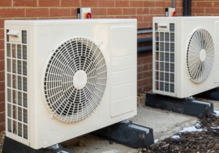 Two air source heat pumps installed on the exterior of a modern house