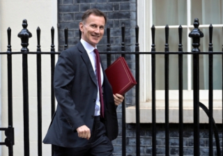 jeremy hunt looking pleased with a briefcase