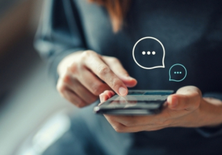 Acre and Simplify to provide automated conveyancing status updates for brokers a woman's hands holding a mobile phone, showing chat bubbles