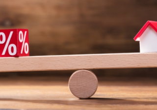 Housing market remains subdued amidst Autumn Budget uncertainty: RICS balancing scales with a house and a percentage sign