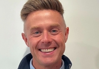 “Don't stress about having your whole career mapped out”: LendInvest’s Ross Bennett on the next generation Man with short hair in a blue jumper and shirt smiling against a white background.