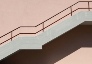 Second charge lending continues double-digit growth: FLA Concrete staircase with brown metallic railing on pink painted facade